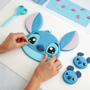 Assembling fondant pieces to create Stitch's face